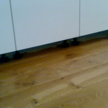Eiken vloer afwerking onder een keuken